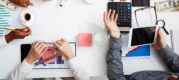 Picture of businessmen's hands on white table with documents and drafts