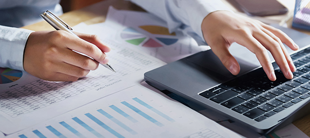 businesswoman working on desk using laptop for check data of fin